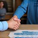 Two fishermen shaking hands with a Perennial Catch representative, symbolizing a successful partnership